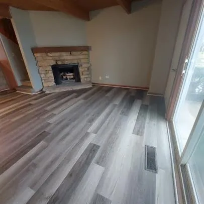 wooden floor in an empty room with a fireplace