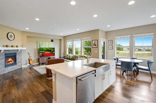 a kitchen that has a lot of cabinets a sink and a wooden floor in it