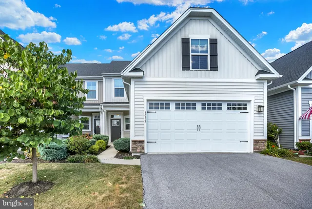 a view of a white house with a yard and garage