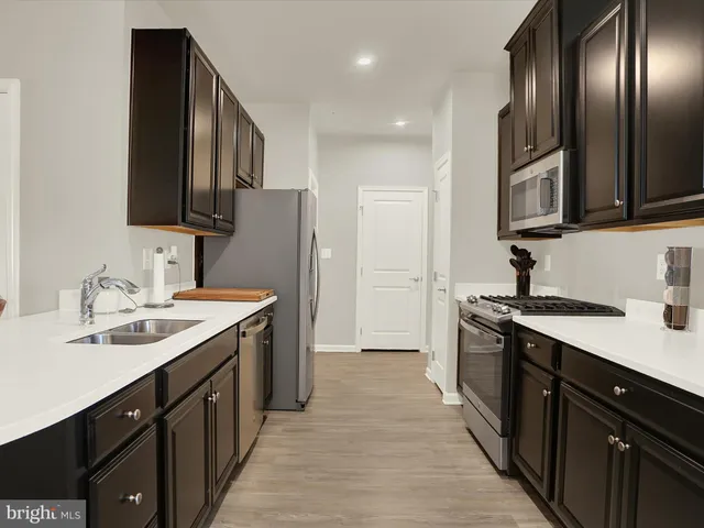 a kitchen with stainless steel appliances granite countertop a stove top oven a sink and dishwasher