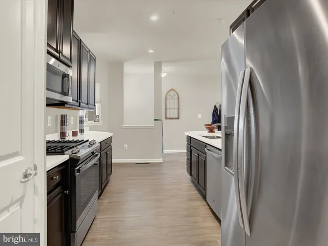a kitchen with stainless steel appliances a sink stove and cabinets