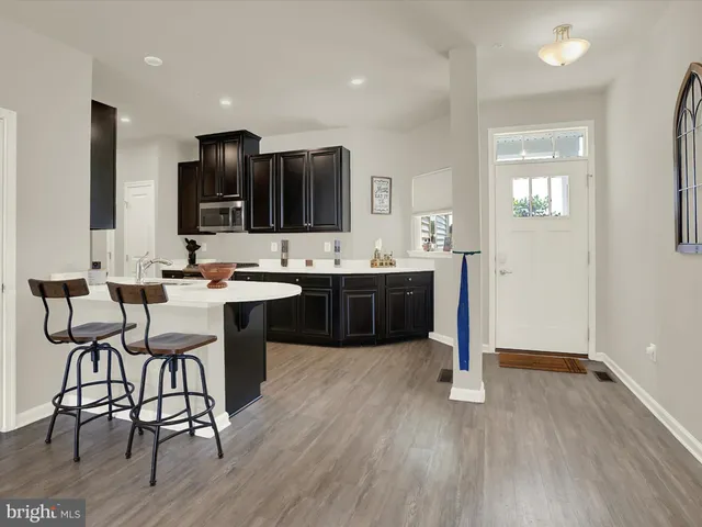 a kitchen with a sink cabinets and wooden floor