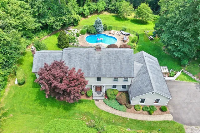 an aerial view of a house with a garden and trees