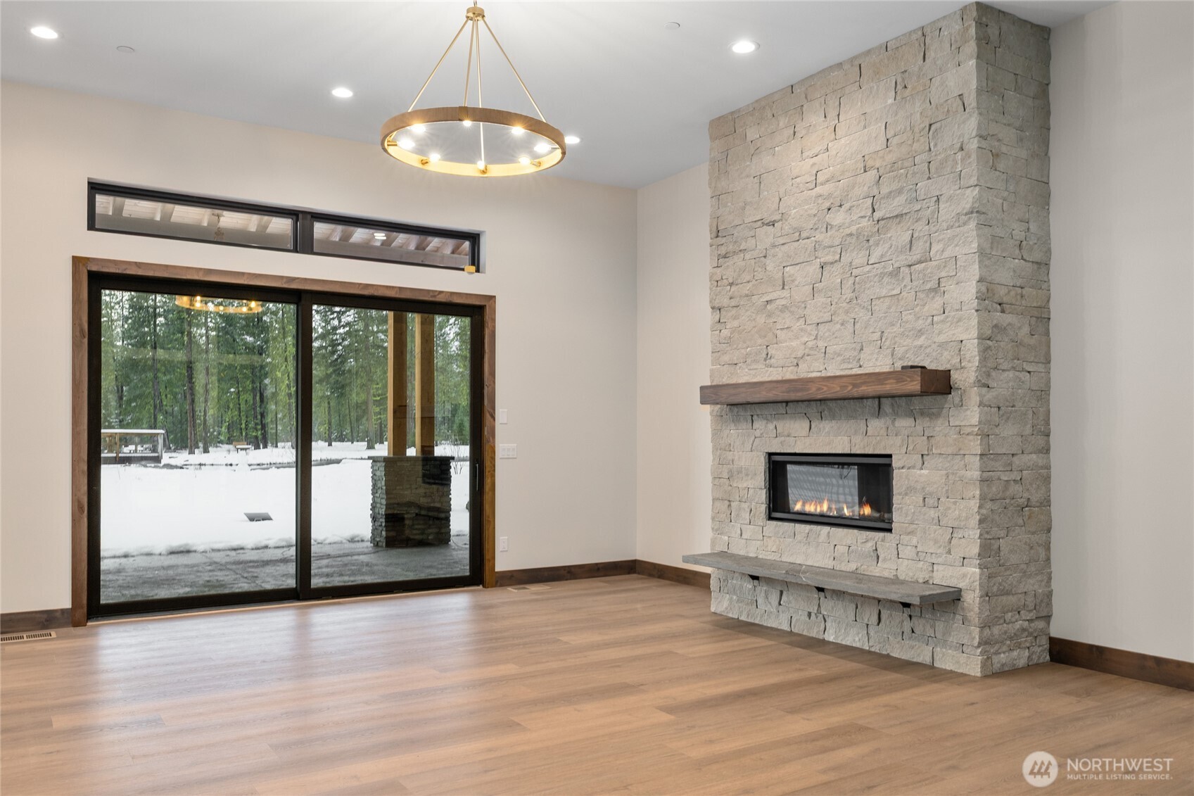 581 Wanawish Loop Cle Elum, WA 98922 - Photo 6 of 40 an empty room with wooden floor fireplace and windows