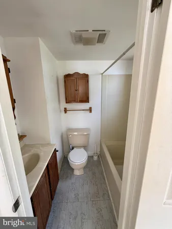 a bathroom with a toilet a sink a bath tub and a window