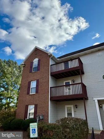 a view of a brick house with large windows and a deck