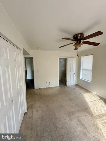 a view of a livingroom with a ceiling fan and window