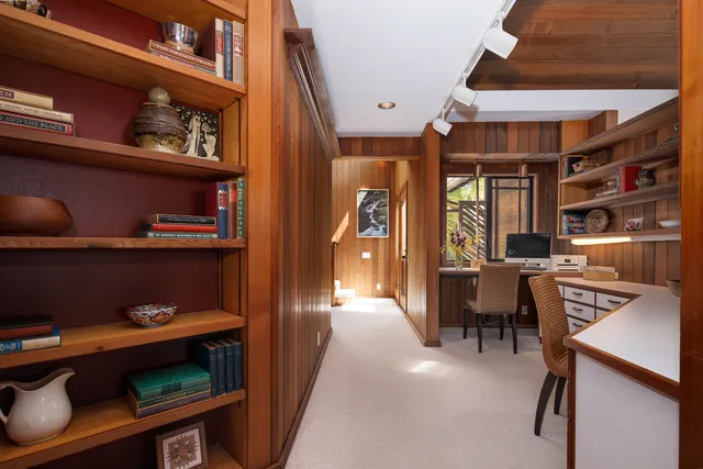 a spacious bedroom with a bed and large windows