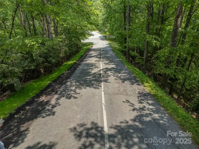 an aerial view of residential house with outdoor space and trees all around