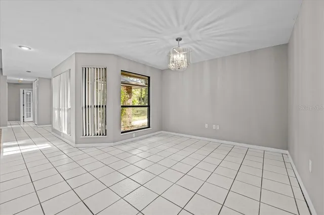 an empty room with windows and ceiling fan