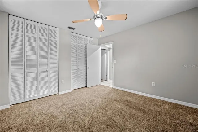 a view of an empty room with a ceiling fan