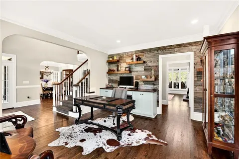 a living room with furniture large windows and wooden floor
