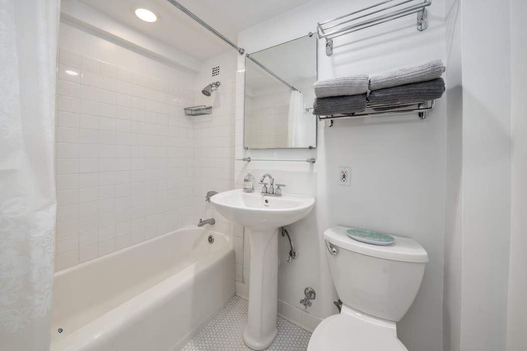 305 East 72nd Street, Unit 5AS Manhattan, NY 10021 - Photo 8 of 11 a bathroom with a sink toilet and shower