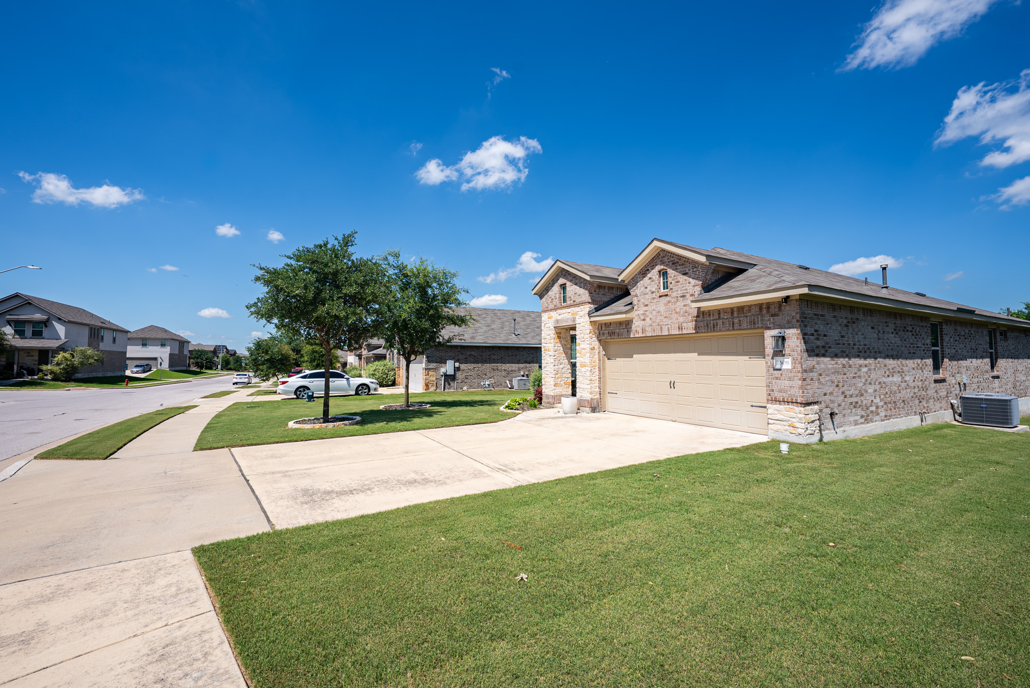 2508 Hat Bender Loop Round Rock, TX 78664 - Photo 2 of 22 Brick and stone exterior featuring a two-car garage