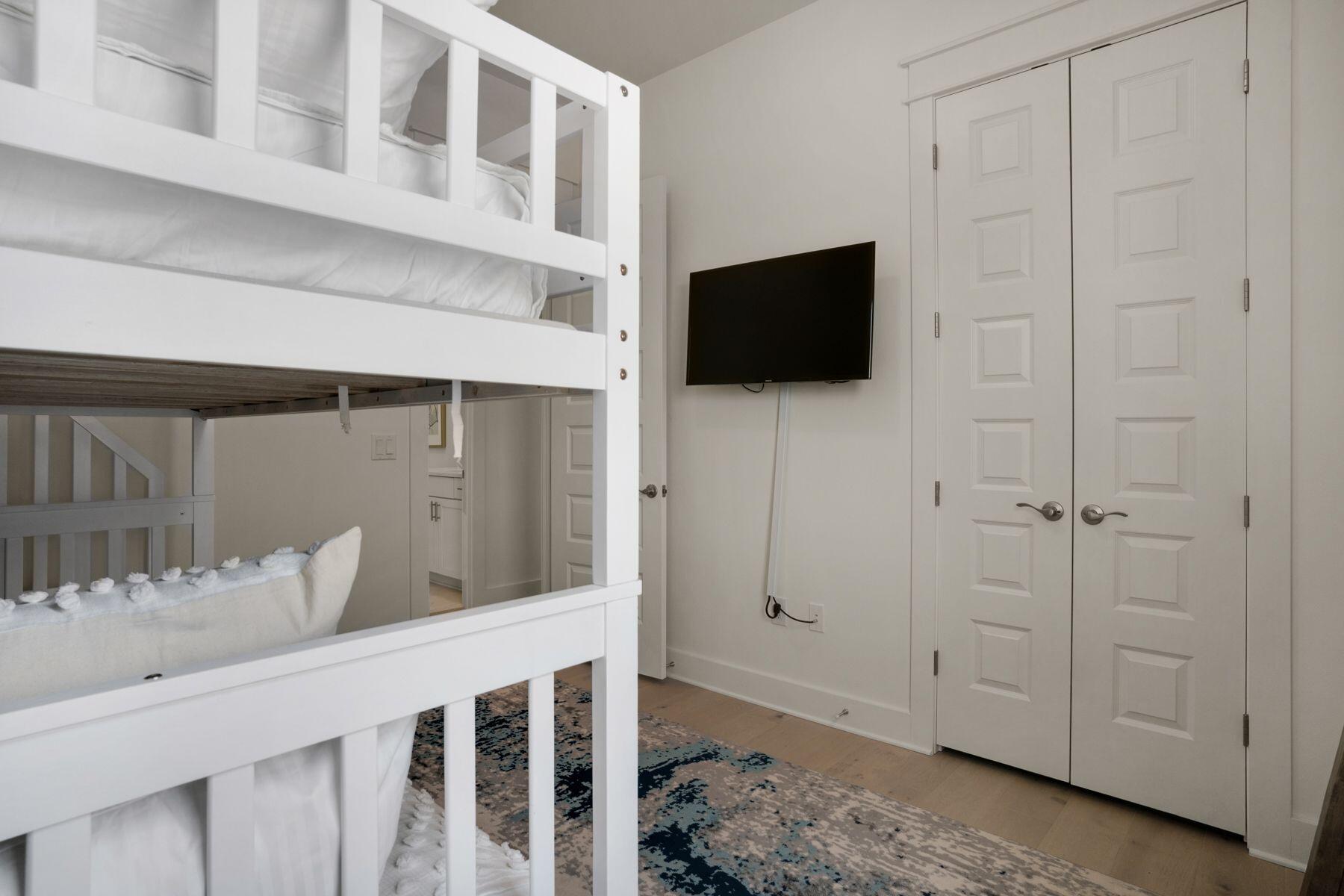 110 Wharf Ln Inlet Beach, Unit A Inlet Beach, FL 32461 - Photo 25 of 27 a bedroom with a bed a flat tv screen and cabinets
