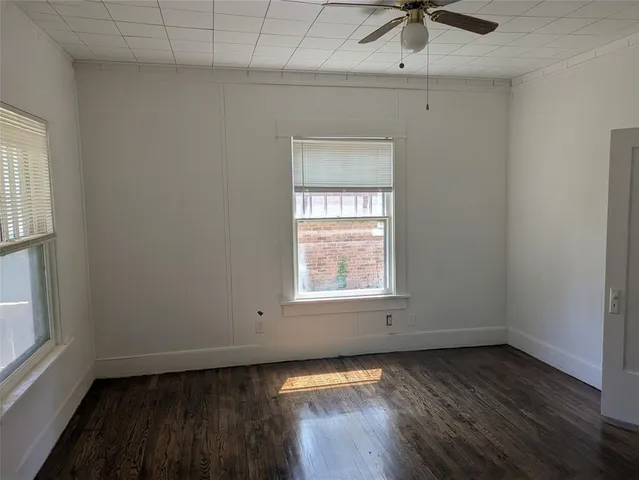 an empty room with a window and wooden floor