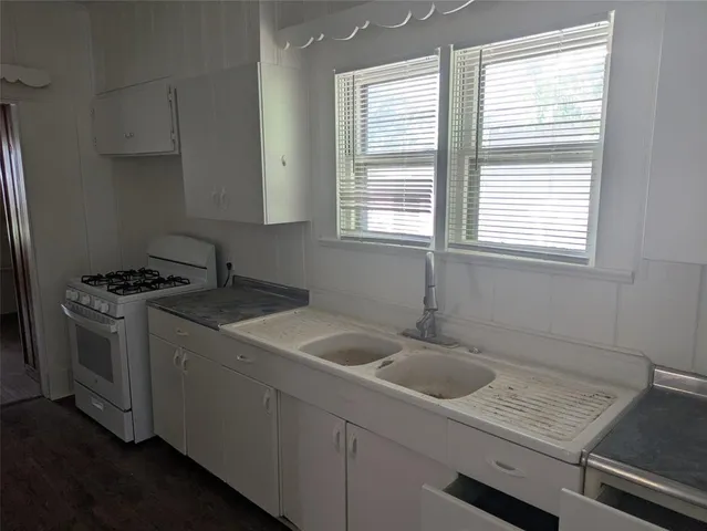 a kitchen with a sink stove and window
