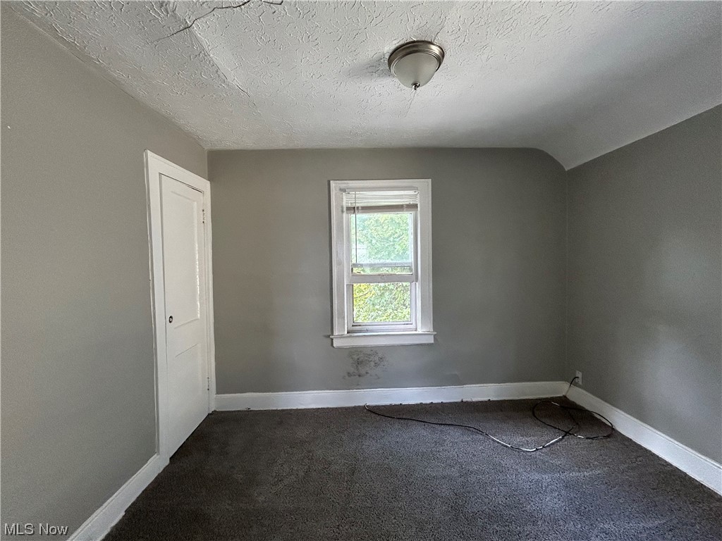14732 Wemple Road Cleveland, OH 44110 - Photo 11 of 14 Empty room with dark carpet and a textured ceiling