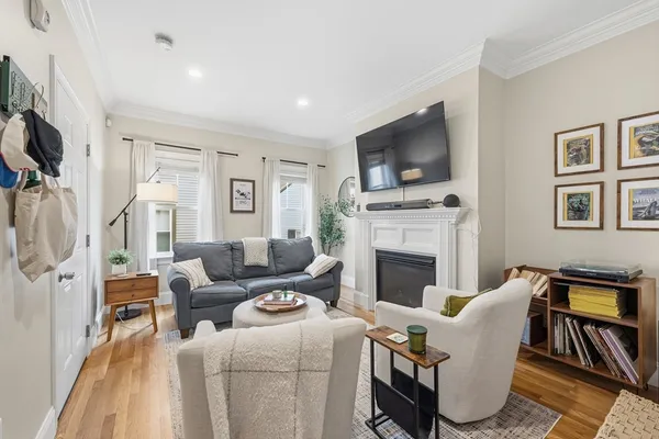 a living room with furniture a flat screen tv and a fireplace