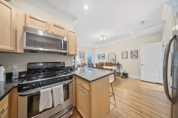 a kitchen with stainless steel appliances a stove cabinets and a wooden floor