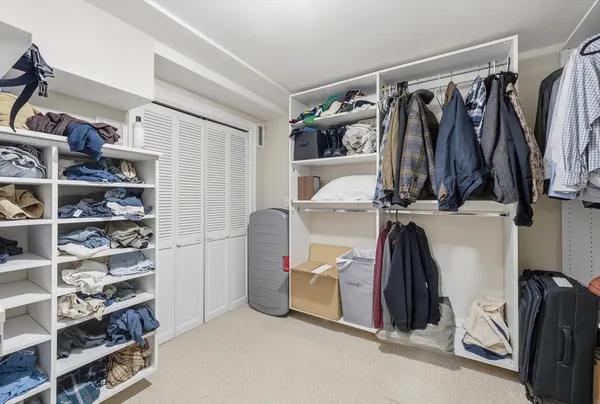 a view of walk in closet with clothes and shoes