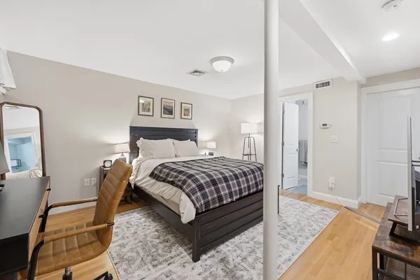 a bedroom with a bed and wooden floor