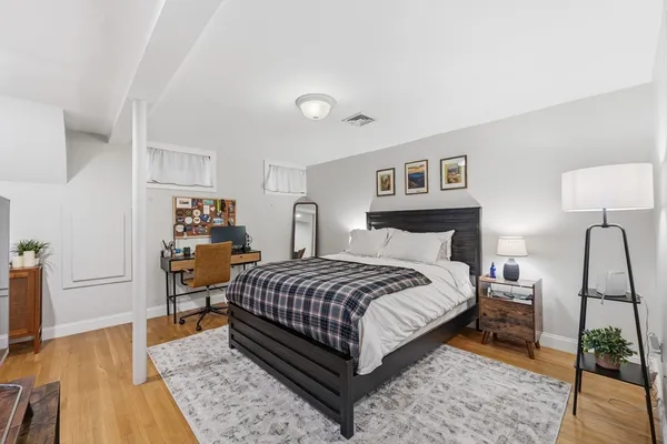 a bedroom with a bed and wooden floor