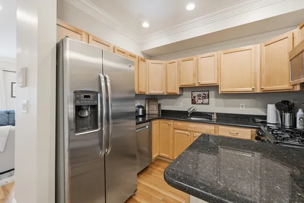 a kitchen with stainless steel appliances granite countertop a refrigerator a stove and a sink with cabinets