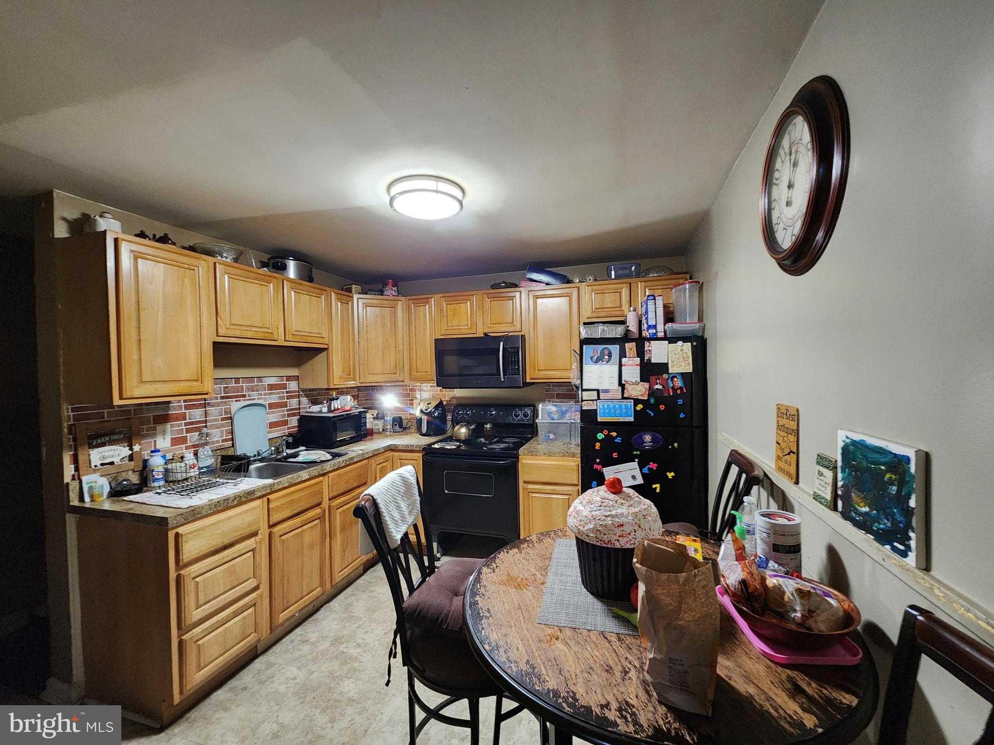 2843 Bookert Drive Baltimore, MD 21225 - Photo 6 of 17 a kitchen with a table chairs stove and microwave