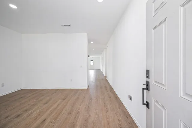 a view of a hallway with wooden floor