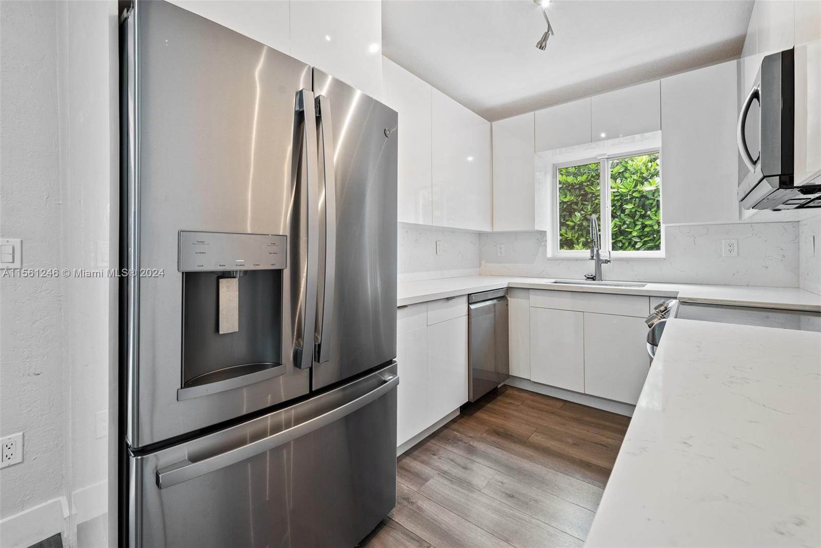 2733 Southwest 15th Street Miami, FL 33145 - Photo 11 of 34 a kitchen with white cabinets stainless steel appliances and window