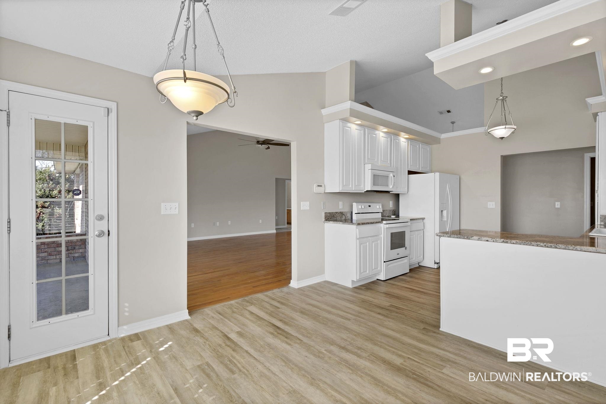10238 Grove Drive Fairhope, AL 36532 - Photo 12 of 39 Kitchen dinette with wood type flooring, lots of natural light and entrance into the sunroom. **Note how the cathedral ceilings flow from the living space to the kitchen area as well.