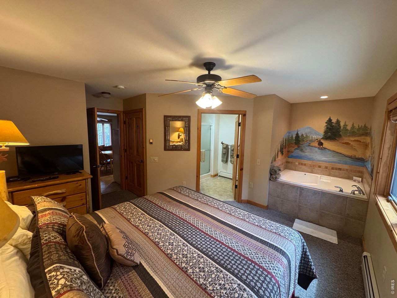2100 Fall River Road, Unit 4 Estes Park, CO 80517 - Photo 10 of 28 a bedroom with a bed and a chandelier