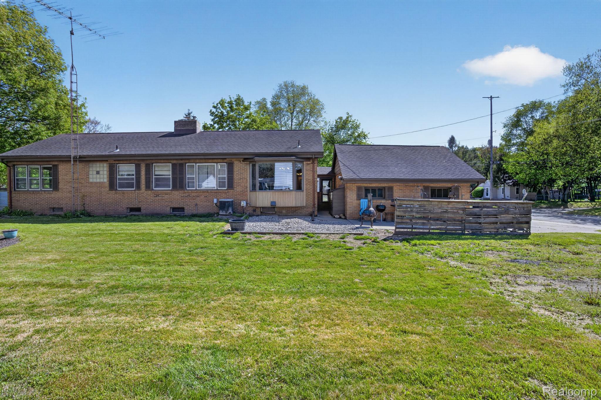 1209 Beatrice Street Flushing, MI 48433 - Photo 34 of 39 Rear view of property with a chimney, an outbuilding, brick siding, a patio area, and a yard