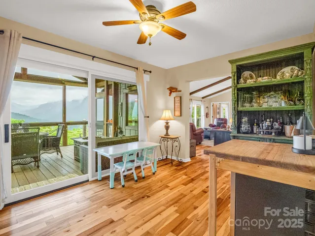 a living room with furniture a flat screen tv and floor to ceiling window