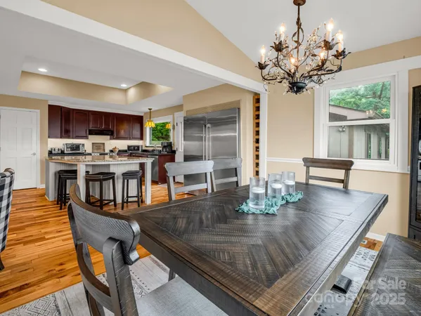 a view of a dining room with furniture a chandelier and wooden floor