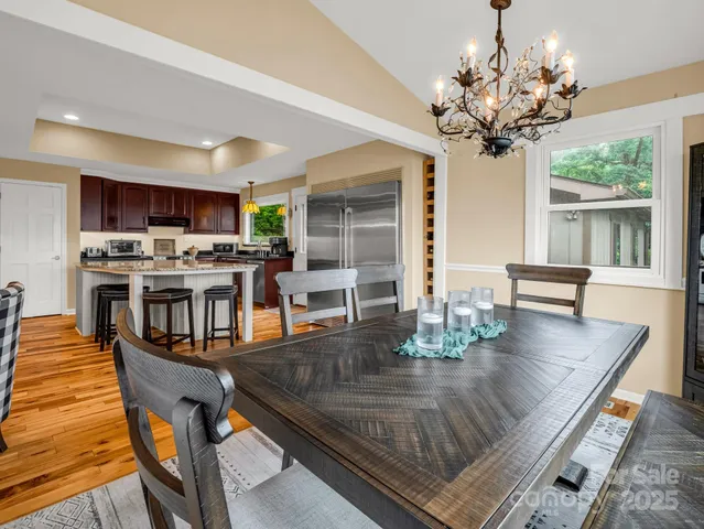 a view of a dining room with furniture a chandelier and wooden floor