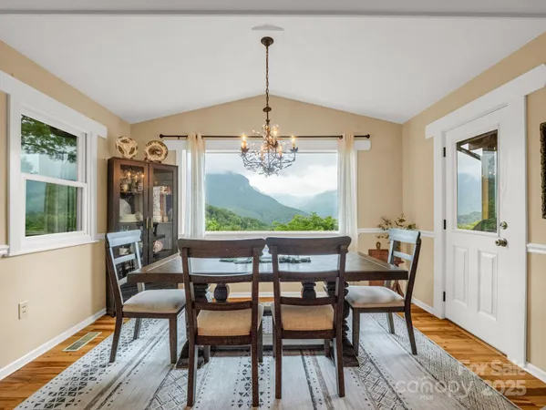 a dining room with furniture a chandelier and wooden floor