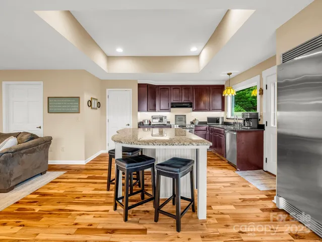 a kitchen with granite countertop a table chairs microwave and cabinets