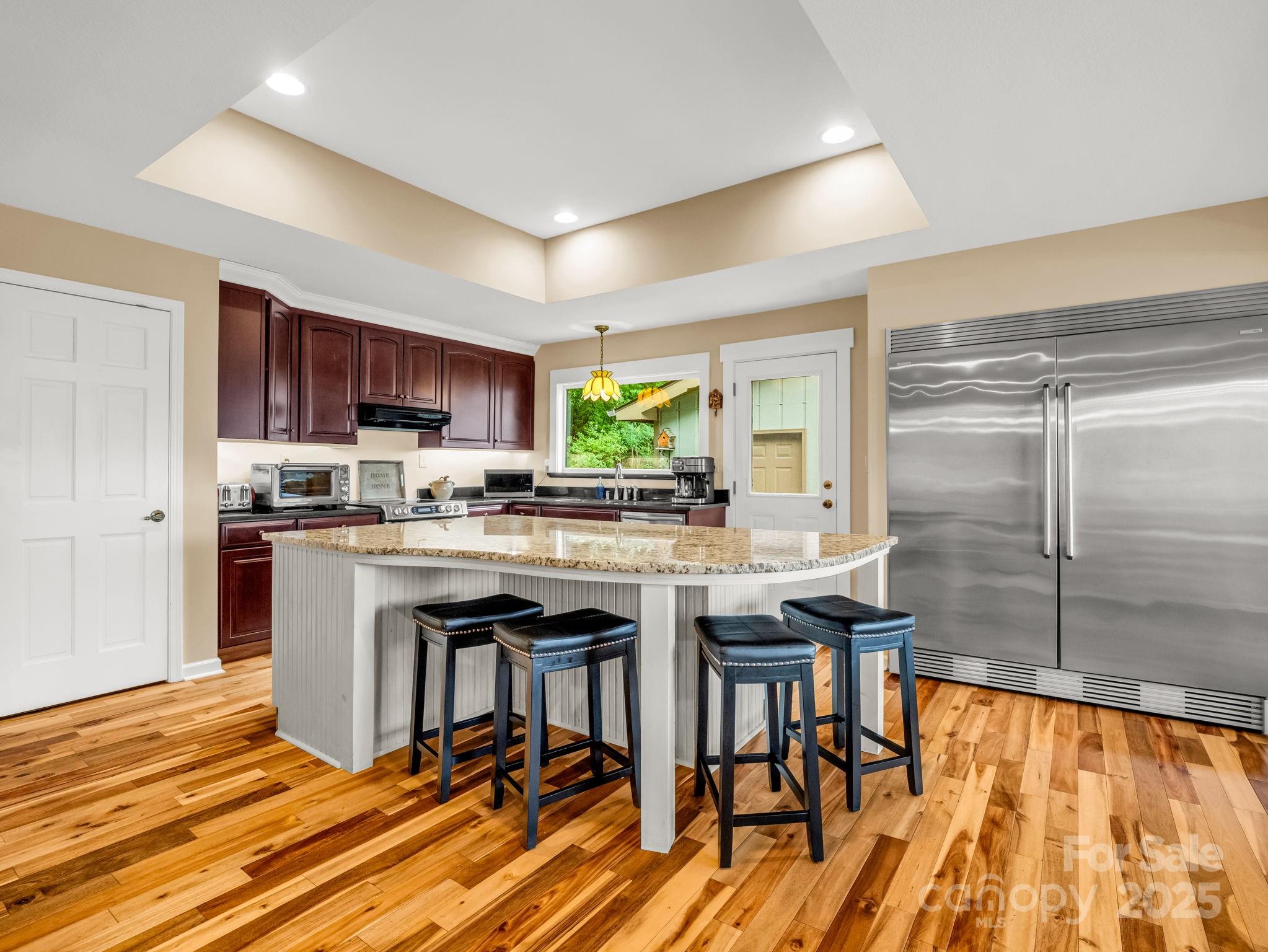 315 Thomas A Edison Rd Lake Lake Lure, NC 28746 - Photo 20 of 47 a kitchen with stainless steel appliances granite countertop a stove top oven a sink dishwasher a dining table and chairs with wooden floor