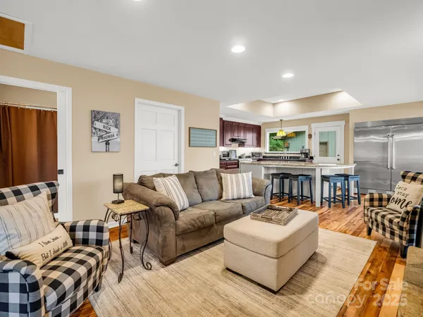 a living room with furniture and a view of kitchen