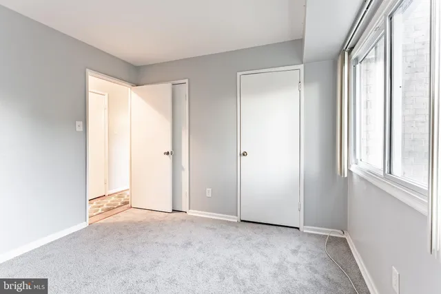 an empty room with windows and closet