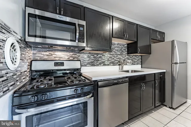 a kitchen with stainless steel appliances granite countertop a stove and a microwave