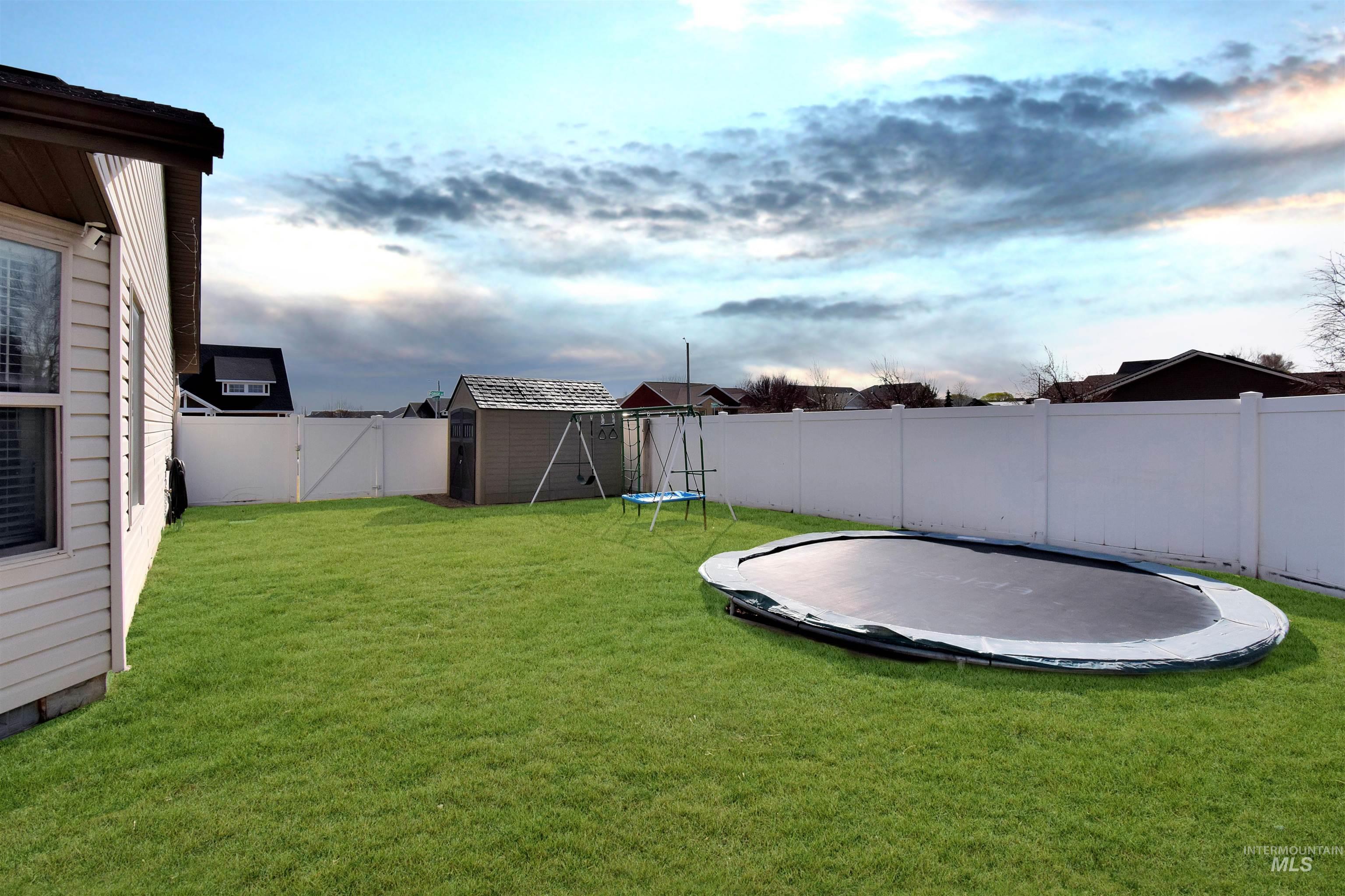 2407 Forge Street Twin Falls, ID 83301 - Photo 19 of 20 Fenced backyard featuring a trampoline, a storage unit, and a gate