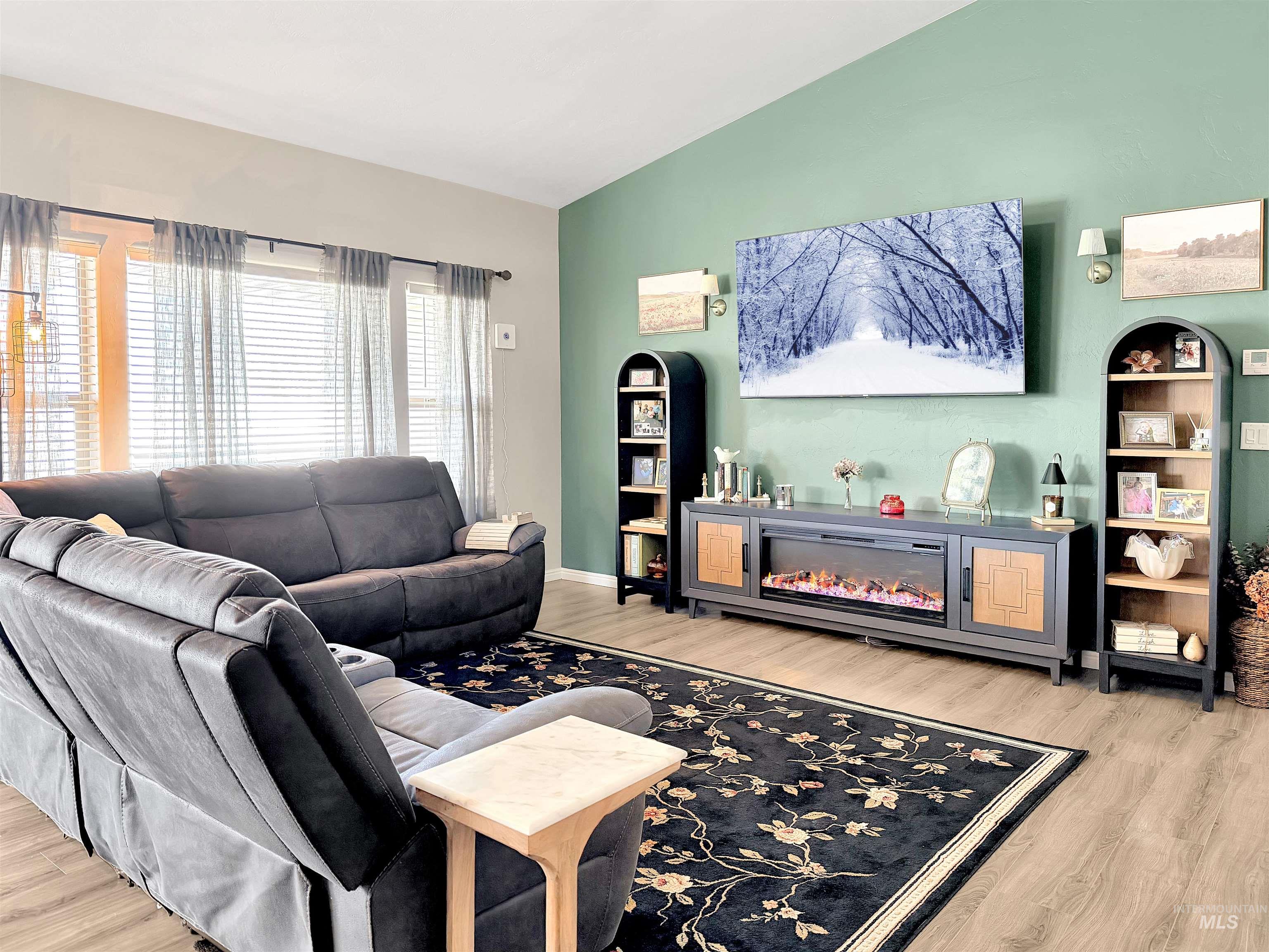 2407 Forge Street Twin Falls, ID 83301 - Photo 3 of 20 Living area with vaulted ceiling, light wood finished floors, and a glass covered fireplace