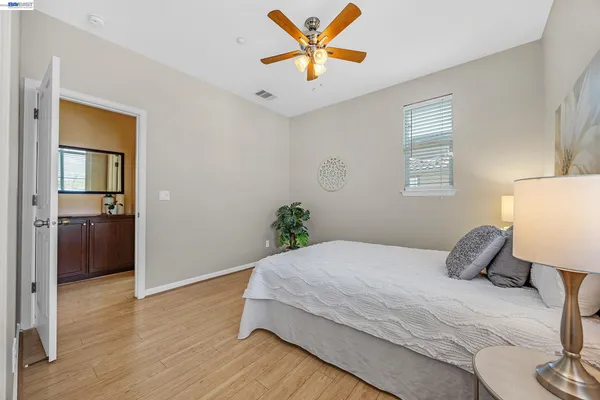 a bedroom with a bed and a lamp on the dresser