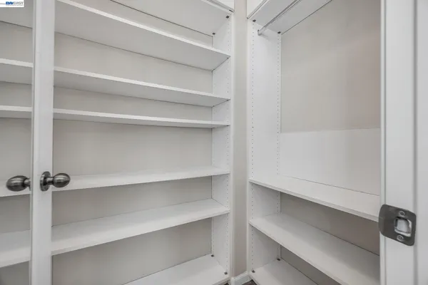 a view of walk in closet with empty racks