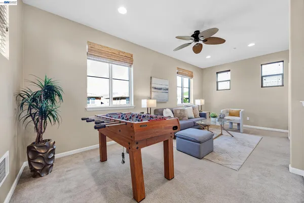 a living room with furniture a window and a potted plant