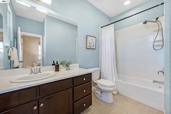 a bathroom with a double vanity sink toilet mirror and shower