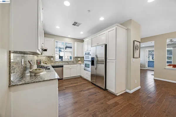 a kitchen with granite countertop stainless steel appliances a refrigerator sink and microwave